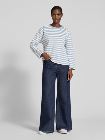 Vrouwenmodel draagt Regular Fit Sweatshirt met afgeronde zoom van TOM TAILOR DENIM in blauw-wit gestreept, ronde hals, lange mouwen, afgewerkte zoom, geheel lichaamsaanzicht van voren.