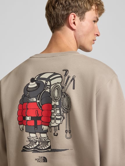 Männermodel trägt Relaxed Fit Sweatshirt aus Baumwoll-Mix mit Label-Detail von The North Face, beige, Print und elastische Abschlüsse, Ganzkörperansicht Rückansicht. Modell 'U GEAR UP GET OUT', Rückenlänge und Ärmellänge bei Größe M je 64 cm.