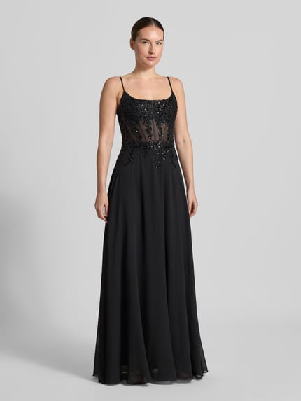 Kobieta prezentuje sukienkę wieczorową 'Abendkleid mit Pailettenbesatz' od Mascara, cekinowe obszycie, kwiatowy wzór, półprzezroczysty materiał, taliowany krój, cienkie ramiączka, Długość tyłu w rozmiarze 36: 131 cm, Szerokość w rozmiarze 36: 39 cm, widok całopostaciowy z przodu.
