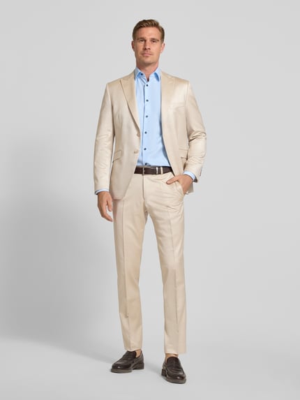 Männermodel trägt Anzughose mit französischen Eingrifftaschen und Bügelfalte von Wilvorst, Viskose-Mix mit Schurwoll-Anteil in Beige, Straight Fit, Knopf-Reißverschluss, Ganzkörperansicht von vorne.