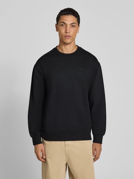 Mannenmodel draagt relaxed fit sweatshirt uit katoenmix van levi's®, effen zwart, Heren sweatshirt, voorkant volledige lichaamsweergave.