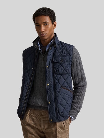 Męski model nosi granatową kamizelkę krój regular fit z naszywką z logo Regular Fit Weste mit Logo-Patch model 'BEATON' od Polo Ralph Lauren, widok całej sylwetki z przodu