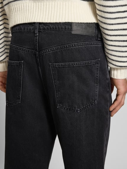 Männermodel trägt Tapered Fit Jeans aus reiner Baumwolle Modell 'RUNNE' von Marc O'Polo Denim in Melange-Optik, Detailaufnahme Rückansicht.