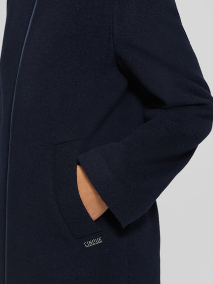 Frauenmodel trägt Mantel aus Schurwoll-Mix mit Kaschmir-Anteil Modell 'MIRALO' von CINQUE in Dunkelblau, Nahaufnahme Oberkörper. Regular Fit, Zweiwege-Reißverschluss, Kapuze, strukturierte Wolloberfläche, Kontext: Rückenlänge 91 cm, Schulterbreite 39 cm, Brustweite 53 cm, Ärmellänge 62 cm.