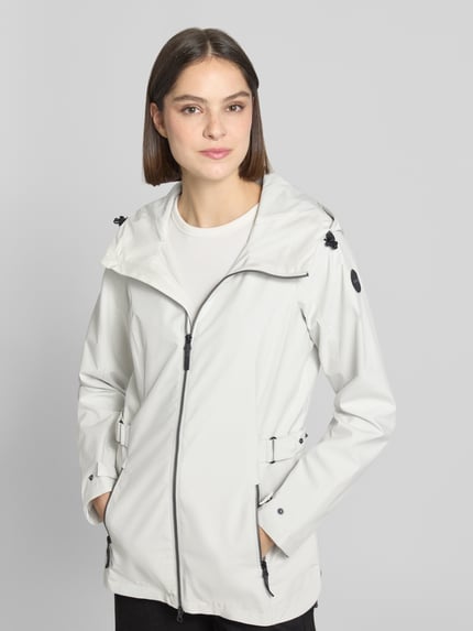 Kobiece model nosi Regular Fit Regenmantel mit Logo-Detail od G.I.G.A. DX, jasnoszary kolor, gładka tekstura, krój regular fit, kaptur z tunelem, zamek błyskawiczny dwustronny, wpuszczane kieszenie zapinane na zamek błyskawiczny, długość tyłu w rozmiarze 36: 76 cm, szerokość ramion w rozmiarze 36: 40 cm, szerokość klatki piersiowej w rozmiarze 36: 50 cm, długość rękawów w rozmiarze 36: 66 cm, detal z logo, gładkie kolory; widok całej sylwetki z przodu.