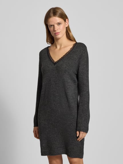Frauenmodel trägt tailliertes Strickkleid mit V-Ausschnitt Modell 'TAMMY' von Only in melange anthrazit, Spitzenbesatz, knielang, Ganzkörperansicht von vorne.