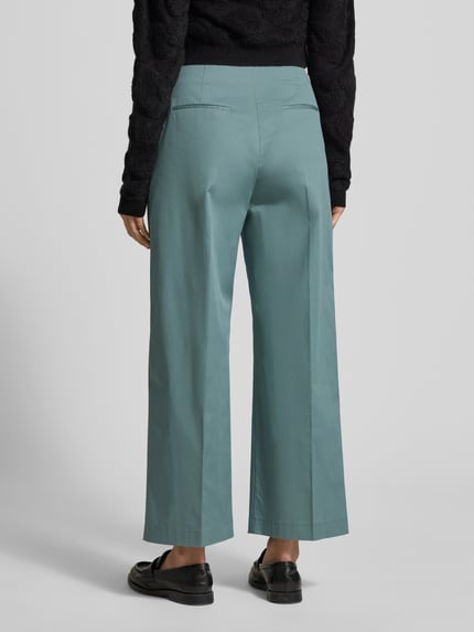 Vrouwenmodel draagt Straight Leg Bundfaltenhose aus Baumwoll-Mix Modell 'TULOTTA' van BOSS in uni blauw, hoge taille, wide leg, rugaanzicht.