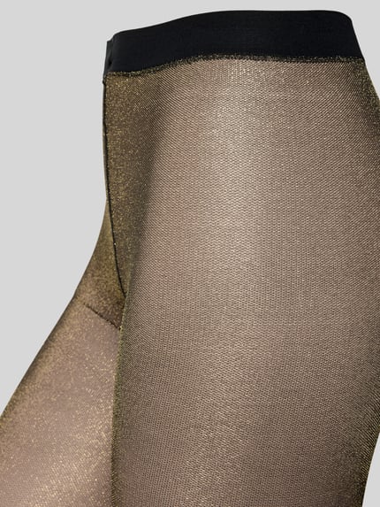 Frauenmodel trägt Schimmernde Strumpfhose mit elastischem Bund von Falke im Glitter-Design, Material-Mix mit Stretch-Anteil, Nahaufnahme Oberkörper.