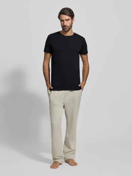 Męski model nosi T-Shirt mit Rundhalsausschnitt im 2er-Pack od MCNEAL, czarny, bawełna, krój slim fit, pełny przód, widok całej sylwetki.