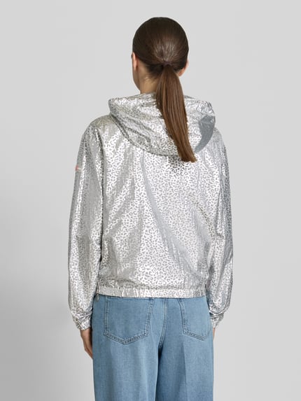 Vrouwenmodel draagt Jacke met Kapuze Modell 'MAY' van Frieda & Freddies in zilvergrijze luipaardprint, recht model, met capuchon met tunnelkoord, tweewegritssluiting, zij-ritszakken, tunnelkoord bij de zoom, elastische mouwboorden, ruglengte maat 36: 58 cm, schouderbreedte: 50 cm, borstwijdte: 56 cm, mouwlengte: 63 cm. Ganzkörperansicht Rückansicht.