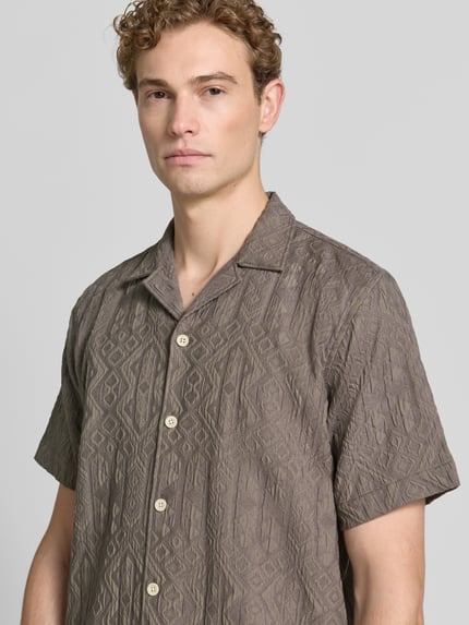 Männermodel trägt Modern Fit Freizeithemd mit Strukturmuster von Lindbergh, Viskose-Mix mit Stretch-Anteil, Reverskragen, Knopfleiste, Nahaufnahme Oberkörper.