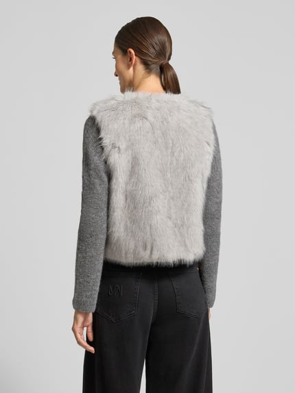 Frauenmodel trägt Weste aus Kunstfell Modell 'Pu44nch' von ZABAIONE in Hellgrau, Regular Fit, strukturierte Oberfläche, Ganzkörperansicht Rückansicht. Rückenlänge bei Größe S: 51 cm, Schulterbreite bei Größe S: 30 cm, Rundhalsausschnitt.
