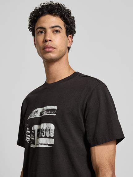 Männermodel trägt Regular Fit T-Shirt mit Logo-Print Modell 'icon' von G-Star Raw aus reiner Baumwolle, Nahaufnahme Oberkörper.