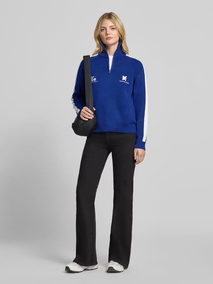 Frauenmodel trägt Sweatshirt aus Baumwollmix von Karo Kauer in Blau mit weißen Kontraststreifen, Logo-Print und Reißverschlüssen, Ganzkörperansicht von vorne.