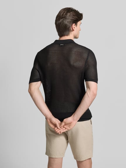 Männermodel trägt Slim Fit Poloshirt mit V-Ausschnitt von Antony Morato aus Baumwoll-Modal-Mix in Schwarz, 1/2-Arm, Rückenlänge 75 cm, Ganzkörperansicht Rückansicht.