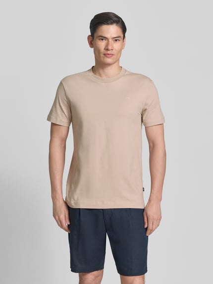 Männermodel trägt T-Shirt mit Rundhalsausschnitt Modell 'Carlonito' von JOOP! Collection aus beigem Baumwoll-Mix, Straight Fit, Ganzkörperansicht von vorne.