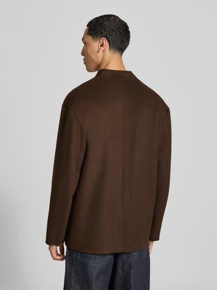 Männermodel trägt Hemdjacke mit Stehkragen von Officine Générale in Braun mit Struktur, aufgesetzte Tasche, Filz, Ganzkörperansicht Rückansicht