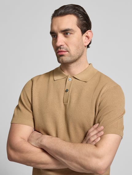 Męski model nosi Koszulkę polo Slim Fit z fakturowanym wzorem model 'Johan' od Christian Berg Men z bawełny, krótki rękaw, kołnierzyk polo, zbliżenie górnej części ciała.