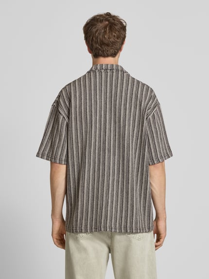 Męski model nosi Relaxed Fit Freizeithemd mit Label-Stitching Modell 'Forno' od Pegador, wzór allover, czarno-beżowe paski, czysta bawełna, krój relaxed fit, kołnierz kent, zapięcie na guziki, długość tyłu w rozmiarze M: 74 cm, szerokość ramion w rozmiarze M: 40 cm, długość rękawa w rozmiarze M: 35 cm, widok całej sylwetki z tyłu.