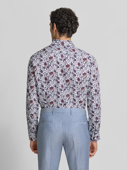 Männermodel trägt Slim Fit Businesshemd aus reiner Baumwolle von Seidensticker, florales Muster in Weiß, Blau und Rot, Ganzkörperansicht Rückansicht, Herren Businesshemd von Seidensticker.