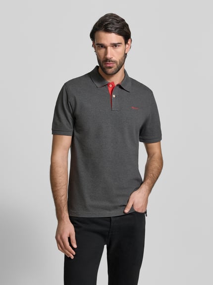 Męski model nosi Regular Fit Poloshirt mit Logo-Stitching od Gant, elastyczna mieszanka bawełny, krój regular fit, szary, krótki rękaw, czerwone detale, przód, ujęcie całej sylwetki od przodu, długość tyłu w rozmiarze M: 70 cm.
