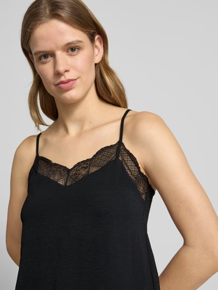 Vrouwenmodel draagt Relaxed Fit Blusentop met Spitzenbesatz model 'TIFFANY' van Pieces, look: effen, pasvorm: relaxed fit, V-hals, applicatie: met kant, model met verstelbare spaghettibandjes, materiaalverwerking: crêpe, Nahaufnahme bovenlichaam.