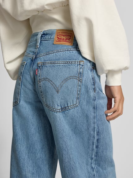 Frauenmodel trägt Regular Fit Baggy Jeans mit Bundfalten von LEVIS in Medium Wash Denim mit 5-Pocket-Design, Ganzkörperansicht Rückansicht.