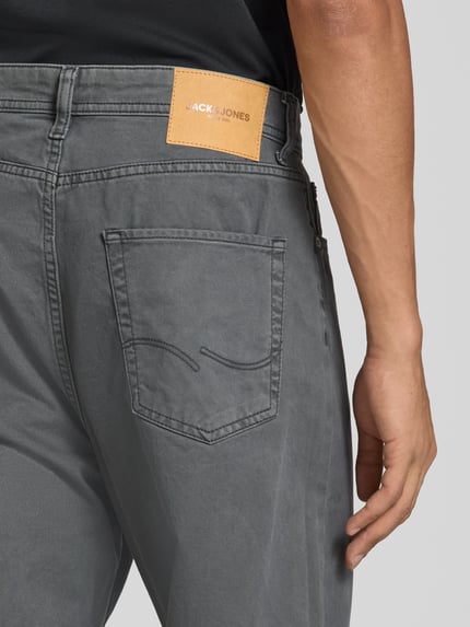 Männermodel trägt Straight Fit Jeans aus reiner Baumwolle Modell 'ALEX ORIGINAL' von JACK & JONES, grauer Stoff mit Taschen, Nahaufnahme Rückansicht, Herren Jeans von JACK & JONES, 5-Pocket-Design, Knopf- und Reißverschluss, Bundweite 43 cm, Innenbeinlänge 73 cm.