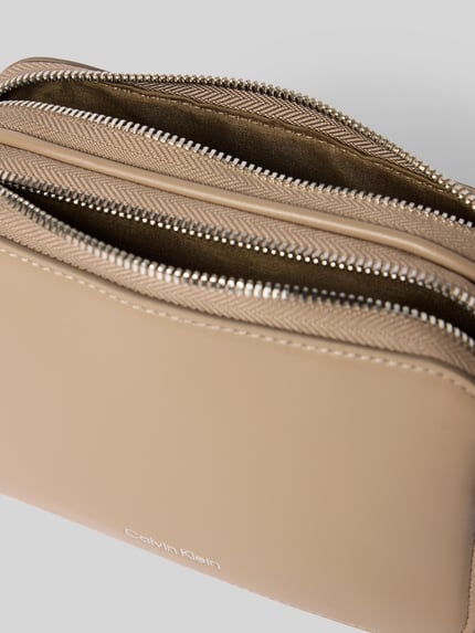 Produktfoto, Crossbody Bag mit Logo-Prägung Modell 'Webbing' von CK Calvin Klein in Beige mit geteiltem Hauptfach, Reißverschluss, Leder-Optik, abnehmbarem und verstellbarem Tragehenkel, Maße: Breite 18 cm, Länge 12 cm, Tiefe 6 cm, Länge Schulterriemen 75 cm.