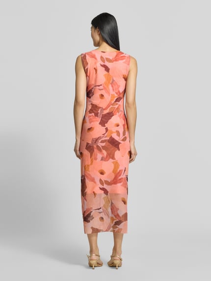 Frauenmodel trägt Slim Fit Midikleid Modell 'Elyra' von Ted Baker mit floralem Allover-Print in Rosa und Orange, Ganzkörperansicht Rückansicht. Elastischer Material-Mix, ärmellos, mit Raffungen, Rückenlänge 129 cm, Brustweite 40 cm.