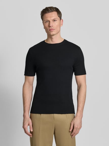 Männermodel trägt schwarzes Herren T-Shirt mit Rundhalsausschnitt Modell 'ENIL' von Drykorn aus reiner Baumwolle, Slim-Fit, Ganzkörperansicht von vorne