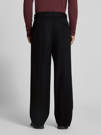 Männermodel trägt Hose aus Baumwoll-Kaschmir-Mix mit Gürtel von Emporio Armani, schwarze Farbe, Relaxed Fit, Bügelfalten, Ganzkörperansicht Rückansicht.