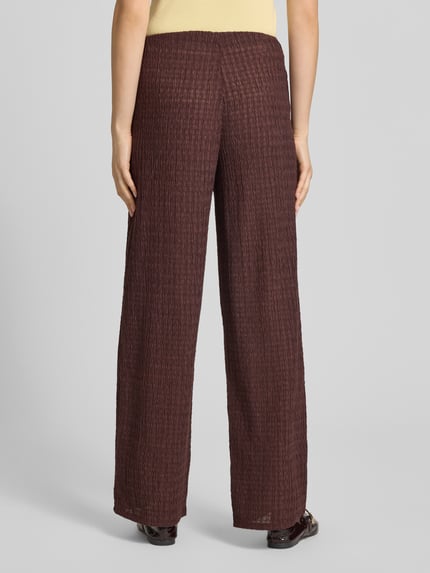 Kobiece model prezentuje spodnie Straight Leg Hose in Strukturoptik Modell 'ILSE' od Only, efekt: jednolity kolor, krój: spodnie z prostymi nogawkami, średni stan, elastyczny ściągacz, wykończenie materiału: marszczenie; całkowity widok od tyłu.