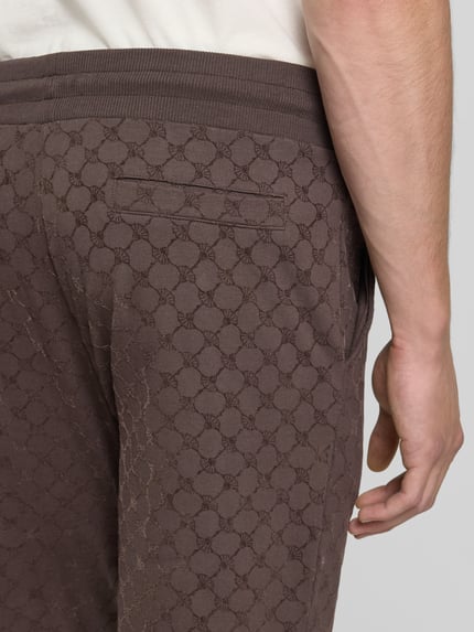 Männermodel trägt braune Herren Sweathose von JOOP! mit Regular Fit T-Shirt aus Baumwoll-Mix Modell 'Korvian', Detailaufnahme Rückansicht.