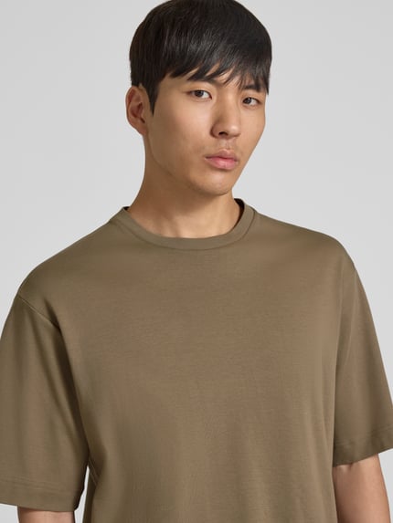 Męski model nosi t-shirt z logo-Print i okrągłym dekoltem od Profuomo z bawełny ekologicznej, krój relaxed fit, długość tyłu 70 cm, Nahaufnahme górnej części ciała.