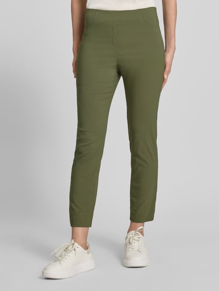 Kobiece modelka nosi Caprihose aus Viskose-Mix Modell 'Igor3' von STEHMANN, krój slim fit, elastyczny pas, kolor oliwkowy, szerokość w rozmiarze 36: 38 cm, długość nogawki od wewnątrz: 69 cm, zbliżenie na dolną część ciała, widok z przodu.