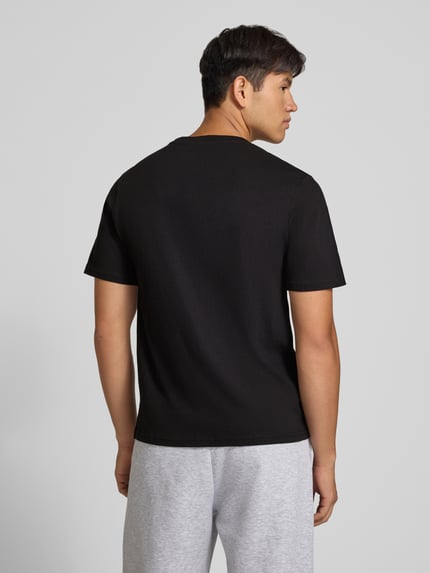 Męski model ma na sobie Regular Fit T-Shirt aus reiner Baumwolle mit Label-Detail von JACK & JONES, czarny kolor, gładka tekstura, krój regular fit, widoczny okrągły dekolt, materiał bawełniany, długość pleców 67 cm w rozmiarze M, całopostaciowy widok z tyłu.