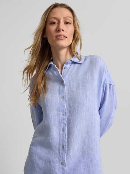 Frauenmodel trägt Regular Fit Hemdbluse aus reinen Leinen von Christian Berg Woman in Hellblau mit Hemdblusenkragen, Knopfleiste, Fransenbesatz, langärmelig, strukturierte Leinen-Optik, Nahaufnahme Oberkörper. Rückenlänge bei Größe 36: 72 cm, Ärmellänge: 55 cm.