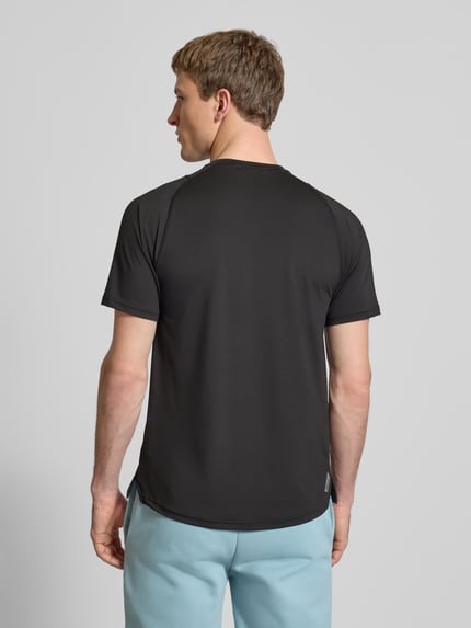 Męski model nosi T-shirt mit Label-Print von PUMA PERFORMANCE, czarny, mieszanka materiałów z dodatkiem streczu, krój regular fit, długość tyłu przy rozmiarze M: 71 cm, całkowity widok z tyłu.