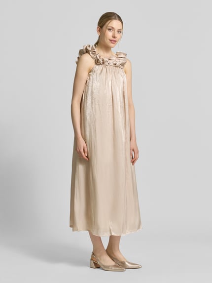 Frauenmodel trägt Relaxed Fit Midikleid mit Zierbesatz Modell 'Turino' von YAS in glänzendem Beige, ärmellos, Ganzkörperansicht von vorne. Damen Midikleid mit lockerem Schnitt, Zierbesatz am Ausschnitt, Länge bei Größe 36 ca. 115 cm, Brustweite ca. 37 cm.