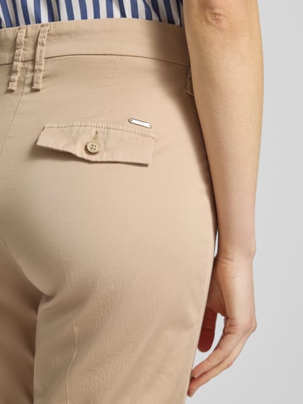 Vrouwenmodel draagt Hose in verkürzter Passform Modell 'Mara S' van Brax, katoen-elastaanmix, beige, detailopname heup, verkorte fit, met vouw, steekzakken, taillewijdte maat 36: 38 cm, binnenbeenlengte maat 36: 68 cm.