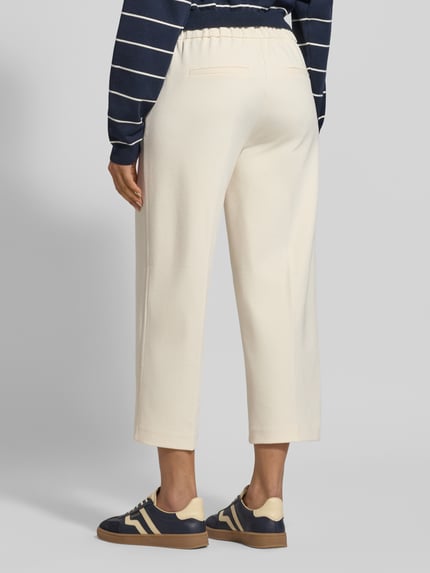 Frauenmodel trägt Regular Fit Caprihose mit Viskose-Anteil Modell 'Culotte' von s.Oliver RED LABEL, unifarben, 3/4-Länge, High Waist, elastischer Bund, seitliche Eingrifftaschen, Ganzkörperansicht Rückansicht.