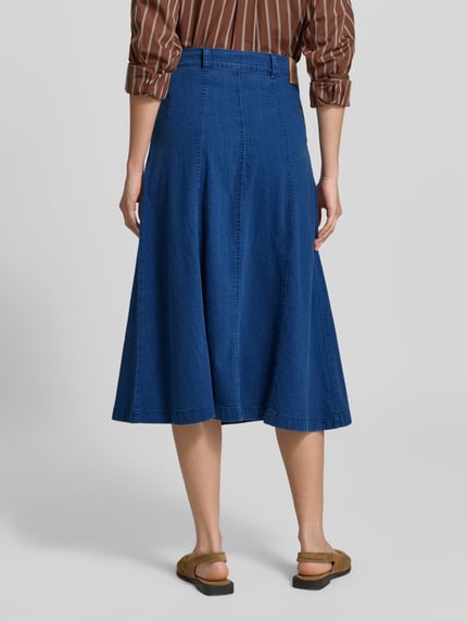 Vrouwenmodel draagt midirok in denimlook van puur katoen, A-lijn, steekzakken, model 'Ally' van Mustang, totale lengte maat 27: 81 cm. Ganzkörperansicht Rückansicht.