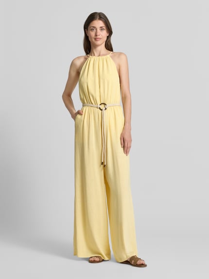Frauenmodel trägt Jumpsuit aus Viskose-Mix mit Gürtel von Apricot in Hellgelb, taillierter Schnitt, fließende Form, Ganzkörperansicht von vorne, Damen Jumpsuit aus Viskose-Mix mit Leinen-Anteil, Rundhalsausschnitt mit Raffungen, Gürtel, seitliche Eingrifftaschen, Schlüsselloch-Ausschnitt hinten, Rückenlänge Größe S 146 cm, Brustweite 48 cm, Gesamtlänge 147 cm, Innenbeinlänge 80 cm.