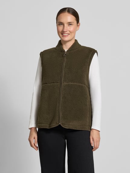 Kobieta nosi oliwkową kamizelkę Regular Fit Weste mit Stehkragen Modell 'SC-ONYX 3' od Soyaconcept, tekstura miękka, widok całej sylwetki z przodu, kontekst: damska kamizelka od Soyaconcept.