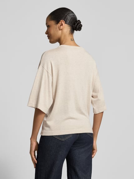 Modelka nosi Strickshirt aus Viskose-Mix Modell 'Conny' von FREE/QUENT, krój relaxed fit, okrągły dekolt, długość tyłu 58 cm, długość rękawów 28 cm, mieszanka wiskozy, widok na całe ciało od tyłu.