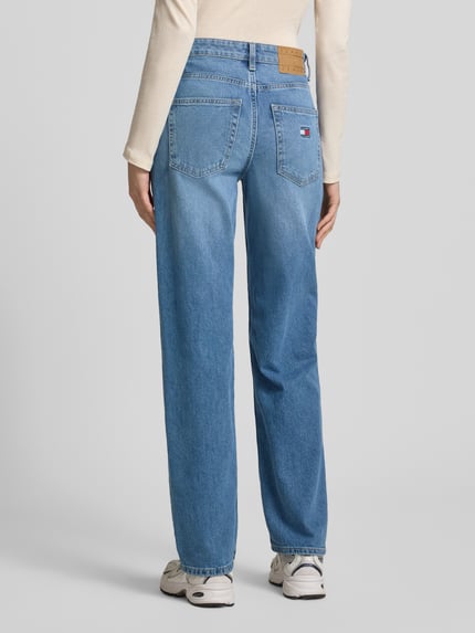 Männermodel trägt Straight Fit Jeans aus Baumwoll-Mix von Tommy Jeans, jasnoniebieski denim, krój straight fit, wysoki stan, label patch, 5 kieszeni, bawełniany materiał, Ganzkörperansicht Rückansicht.
