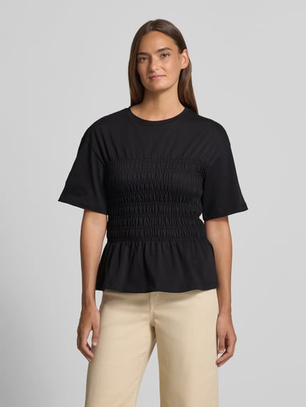 Frauenmodel trägt T-Shirt mit Smok-Details und Rundhalsausschnitt von Jake*s Casual aus Reine Baumwolle, Slim-Fit, schwarze Farbe, Ganzkörperansicht von vorne. Rückenlänge bei Größe S: 54 cm.