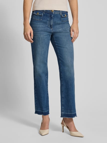 Frauenmodel trägt Jeans im Used-Look mit Fransen von LUISA CERANO aus Baumwoll-Elasthan-Mix, Straight Fit, blaue Textur, Nahaufnahme Oberkörper.