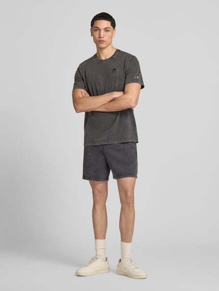 Männermodel trägt Sweatshorts mit Eingrifftaschen von CHAMPION in dunklem Grau, Baumwoll-Mix, Regular Fit, Ganzkörperansicht von vorne.